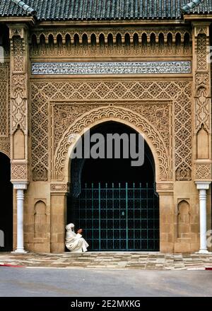 1970s DEVOUT MAN WHITE ROBES AND HEADDRESS SITTING AT ENTRANCE TO BUILDING IN RABAT MOROCCO GATED DOORWAY WITH INTRICATE DESIGNS - kr16526 LAN001 HARS CAPITAL GATED HEADDRESS MOROCCAN FAITHFUL FAITH ISLAM ISLAMIC BERBER DESIGNS DEVOUT INTRICATE MOROCCO MOSLEM NORTH AFRICA OLD FASHIONED Stock Photo