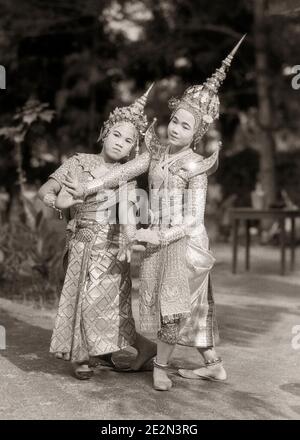 1930s TWO FEMALE TRADITIONAL SIAMESE CLASSICAL DANCERS WEARING ELABORATE COSTUMES AND HEADPIECES PERFORMING IN BANGKOK THAILAND - q405 HAR001 HARS MYSTERY COSTUMES LIFESTYLE CELEBRATION FEMALES COPY SPACE FULL-LENGTH LADIES PERSONS TRADITIONAL TEENAGE GIRL ENTERTAINMENT SIBLINGS SPIRITUALITY SISTERS B&W FORM PERFORMING AND DRAMATIC EXTERIOR TRADITION OCCUPATIONS SIBLING THAILAND CONCEPTUAL ESTABLISHED STYLISH BANGKOK THAI JUVENILES PRE-TEEN PRE-TEEN GIRL TOGETHERNESS YOUNG ADULT WOMAN BLACK AND WHITE ELABORATE HAR001 OLD FASHIONED Stock Photo