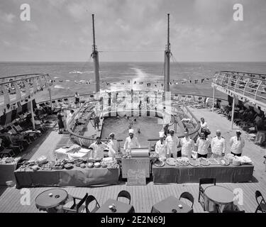 1950s BUFFET LUNCH SERVING CREW STAFF ASSEMBLED ABOARD THE AFT DECK BY SWIMMING POOL ON THE CRUISE SHIP SS INDEPENDENCE AT SEA - s11969 RGE001 HARS BUFFET LUXURY COPY SPACE FULL-LENGTH LADIES PERSONS MALES PROFESSION SHIPS TRANSPORTATION AFTER B&W TIME OFF SKILL TEMPTATION OCCUPATION SKILLS HIGH ANGLE ADVENTURE LEISURE CUSTOMER SERVICE TRIP GETAWAY CAREERS RECREATION LABOR PRIDE AT BY ON THE EMPLOYMENT HOLIDAYS OCCUPATIONS CONCEPTUAL SERVERS STYLISH ASSEMBLED EMPLOYEE AFT SS STAFF TOQUE VACATIONS ABOARD BLACK AND WHITE FOOD PREPARATION LABORING OLD FASHIONED VESSEL Stock Photo