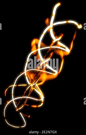 Lightbulb(s) and their glowing filaments shot in a dark interior of an upscale modern western-style saloon.  Orange and yellow glowing tones. Stock Photo