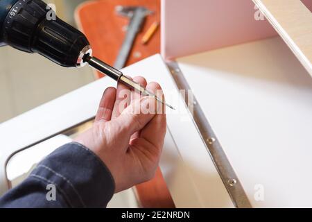 Carpenter at work. Preparing screwdriver for working on play furniture copyspace Stock Photo
