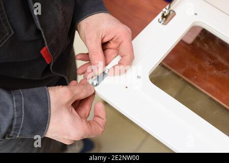 Carpenter working on play kitchen oven door closeup Stock Photo