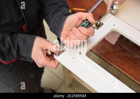 Carpenter working on white color play kitchen oven door closeup Stock Photo