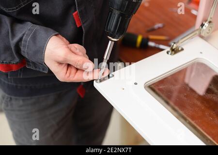 Carpenter working on play kitchen oven door close up Stock Photo