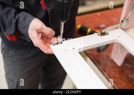 Carpenter working on white color play kitchen oven door closeup Stock Photo