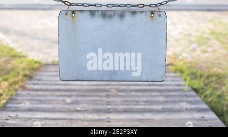 Close up gray blank plate on chain at street background, text place Stock Photo