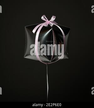 Single silver present gift box balloon ballon object with pink stripe for birthday or valentines day on dark gray  Stock Photo