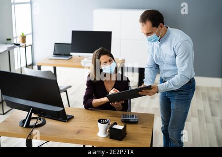 Employee Assistant Training Wearing Face Mask In Office Stock Photo