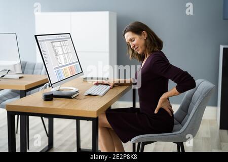 Back Pain At Work. Bad Computer Posture Stock Photo