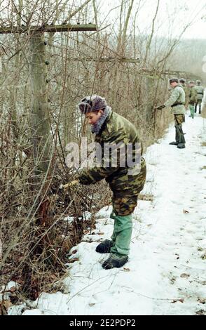 'Moldovan border guards removing the barbed wire between Moldova and Romania at Cotul Morii. February 16th, 2010, Moldova. Moldovan Prime Minister Vlad Filat has signed an order to remove a 60-year-old communist-era barbed wire along the Prut River, separating his country from Romania. Filat described the fence as an embarrassment, saying that ''maintaining the fence along the border with a friendly country in the 21st century, when Europe's borders are entirely transparent and people move freely, is a shame.''. Photo by Dorin Goian/ABACAPRESS.COM' Stock Photo