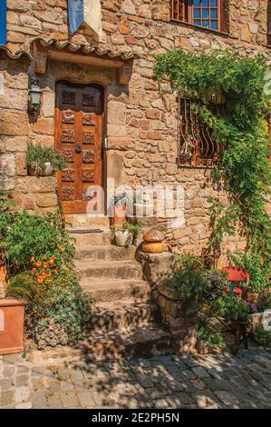 Close-up of stone house facade with bindweed and staircase, at the medieval hamlet of Les Arcs-sur-Argens, near Draguignan. Provence region, France. Stock Photo