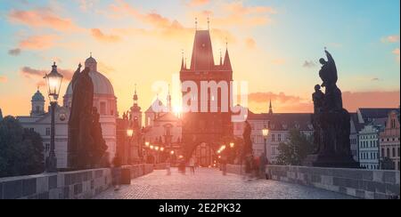Charles Bridge at dawn: silhouettes of Old Bridge Tower, churches and spires of Old Prague, panoramic banner image.