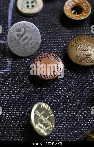 Buttons on denim fabric in workshop Stock Photo