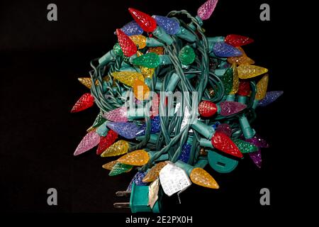 Colorful Christmas lights rolled up  on a black background Stock Photo
