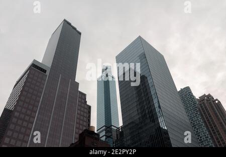 new york city skyscrapers lean into the vanishing point in a white cloudy sky to create a triangular, geometric architectural scene on the skyline Stock Photo