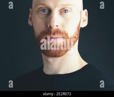 A young Male portrait with a Ginger beard looking frontal in a camera and make a kindly face Stock Photo