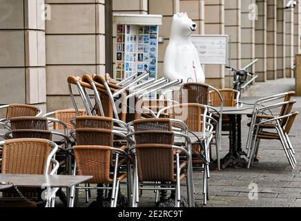 Berlin, Germany. 14th Jan, 2021. Stacked chairs and blocked tables from Cafe Lebensart stand on Unter dem Linden. A Berlin bear can be seen in the background. Due to the lockdown, shops, cafes and restaurants are closed. Credit: Jens Kalaene/dpa-Zentralbild/ZB/dpa/Alamy Live News Stock Photo