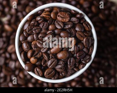 Takeaway coffee recycle cup with roasted coffee beans on coffee beans background. Top view. Close up. Selective focus. Stock Photo