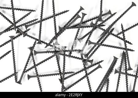 A bunch of self-tapping screws for wood surfaces on a white background. Metal fasteners. Stock Photo