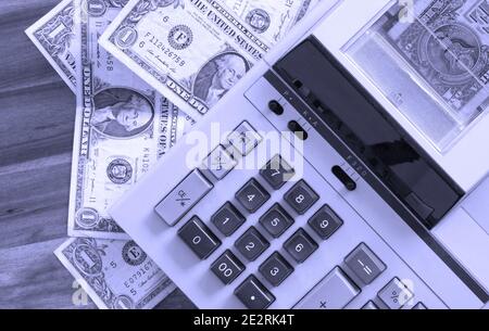 Old fashioned calculator and dollars on a desk Stock Photo