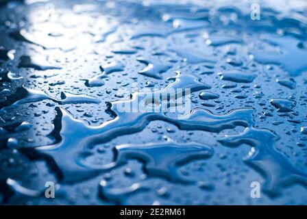 Droplets of water on a blue shiny surface Stock Photo