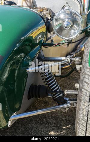 Close up detail of the front suspension and wheel on a British racing green 1960s Lotus Seven lightweight open top sports car Stock Photo