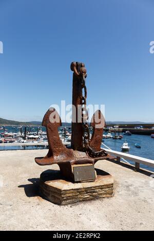 Anchor from the cargo ship Cason, Memorial in Finisterre with the marina as background, Galicia, Spain Stock Photo