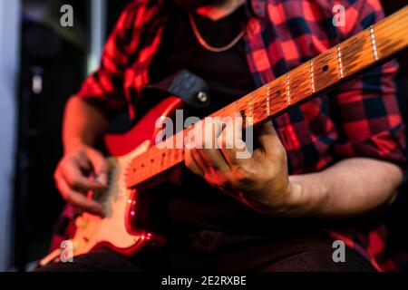 Close up white young male is playing electric guitar in the record studio. Photo about musical instruments . Stock Photo