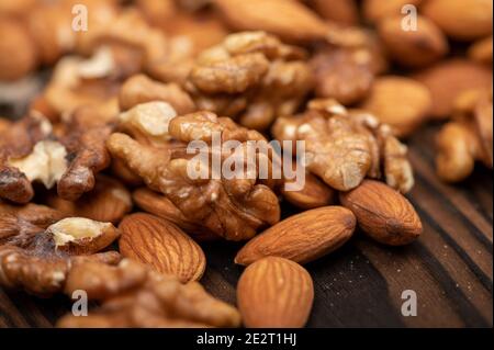Almonds and walnuts scattered on the table. Close-up, selective focus Stock Photo