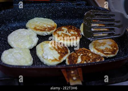 Fry cheese cakes at home in a pan Stock Photo