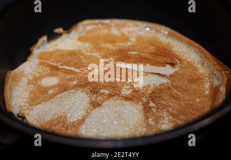 Pancake on frying pan. Making of pancakes. Stock Photo