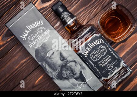Kharkiv, Ukraine, January 14, 2021: Full bottle and glass of Jack Daniel's # 5 American Whiskey on dark brown wooden planks. Strong drink. The old Ten Stock Photo