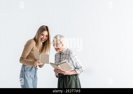 happy young woman reading book with granny in glasses isolated on white Stock Photo