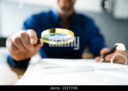 Fraud Detective Using Magnifying Glass Or Loupe Stock Photo