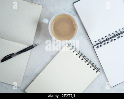 White workplace top view. Empty Notebooks on the table. On the desktop are notebooks, coffee and pen. Modern work or study postation for business or s Stock Photo
