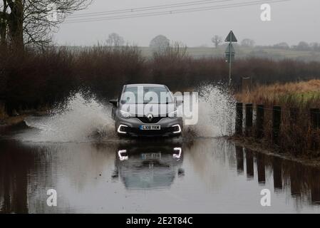 Leicester, Leicestershire, UK. 15th January 2021. UK weather.  A car is driven through flooding in Loughborough after the Met Office warned of below freezing temperatures across many parts of England after heaving rain and snow. Credit Darren Staples/Alamy Live News. Stock Photo
