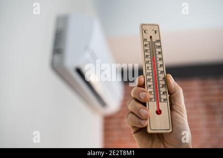 Home Air Condition On Wall And Thermometer With Low Temperature Stock Photo