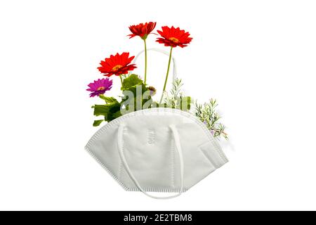 KN-95 mask as basket with bouquet of flowers isolated on blank background. Optimistic concept of the covid-19 pandemic Stock Photo