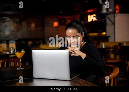 Portrait of a business woman working on a laptop in a restaurant, social media concept, video conferencing. Stock Photo