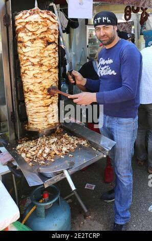 ADANA,TURKEY-APRIL 9:Unidentified Guy slicing Chicken Doner Kebab with sword like long knife  at Orange Blossom Carnival.April 9,2017 in Adana,Turkey. Stock Photo