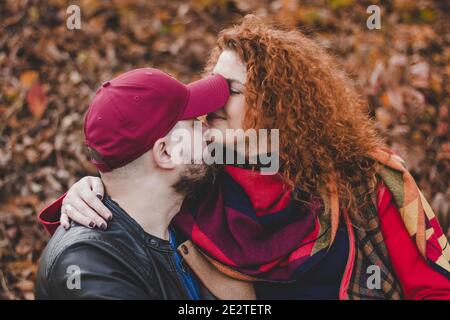 Happy couple in love embraces and has fun outside in the nature background. Woman is pregnant. Happy new parents. Stock Photo