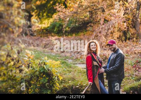 Happy couple in love embraces and has fun outside in the nature background. Woman is pregnant. Happy new parents. Stock Photo