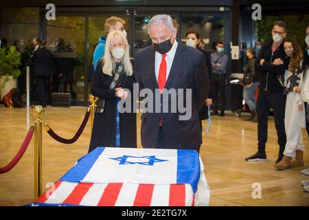 Lod, Israel. 14th Jan, 2021. Israeli Prime Minister Benjamin Netanyahu stands before the casket of Sheldon Adelson, with his wife, Miriam Adelson, upon arrival to Ben Gurion Airport, near the city of Lod, Israel, Thursday, Jan. 14, 2021. Adelson, the billionaire mogul and power broker who built a casino empire spanning from Las Vegas to China and became a singular force in U.S. domestic and international politics has died after a long illness, his wife said Tuesday, January 12, 2021. Pool Photo by Ami Shooman/UPI Credit: UPI/Alamy Live News Stock Photo