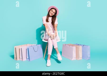 Portrait of her she nice-looking attractive pretty cute cheerful cheery girl fashionista sitting in chair among bags new clothes isolated on bright Stock Photo