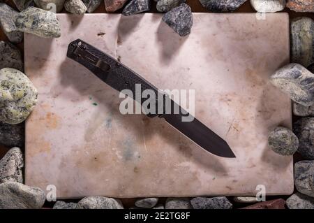 The knife is located in the frame. Knife on a marble board. Stock Photo