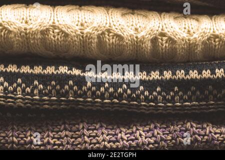 Bunch or pile of knitted woolen sweaters moody photo with texture Stock Photo