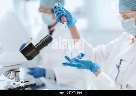 close up. female scientist examining a liquid in a laboratory flask . Stock Photo