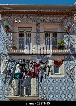 Laundry drying at azulejo decorated house on Travessa do Paraiso, near National Pantheon (Panteao Nacional), Alfama neighborhood, Lisbon, Portugal Stock Photo