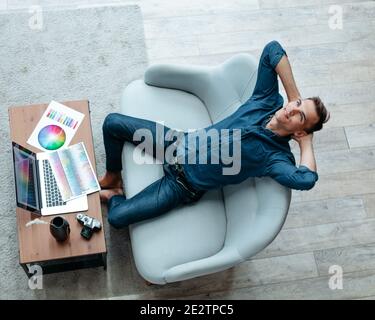 dreamy male designer sitting at his Desk . Stock Photo
