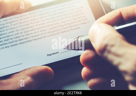 electronic signature concept - man sign distance contract with digital pen in mobile phone Stock Photo